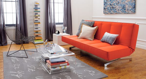 A bright orange sleeper sofa in a modern living room