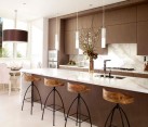 Exquisite modern kitchen in white and brown with sleek pendant lights above the kitchen island