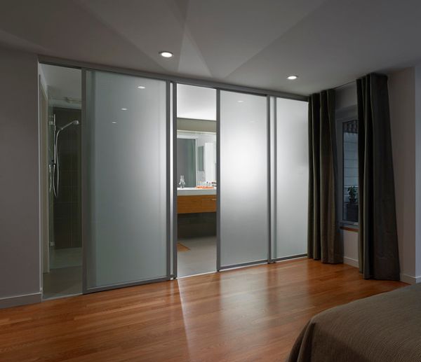 Frosted glass sliding doors separate the contemporary bedroom from the ...