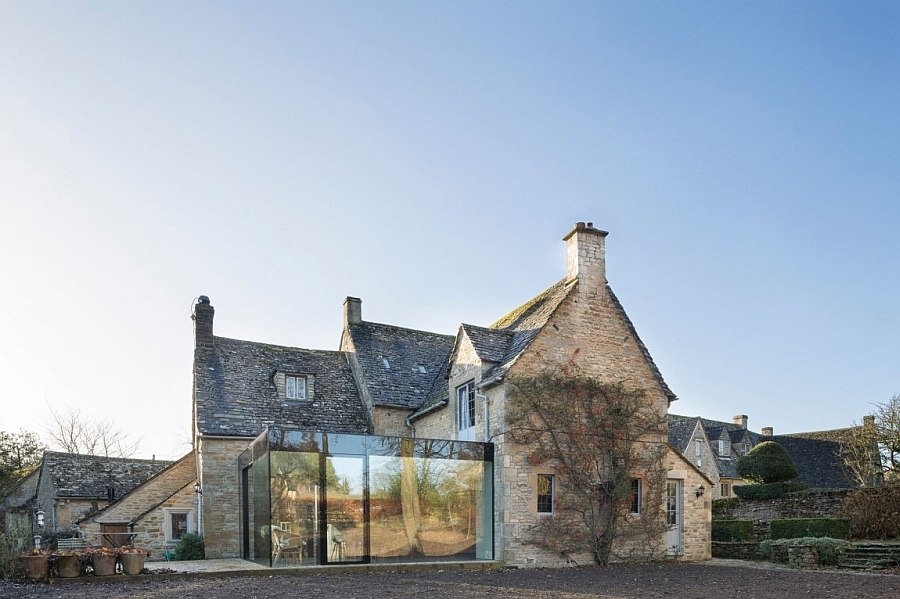 Lovely glass extension reflects the garden landscape outside during daytime