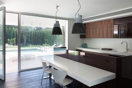 Low kitchen volume that is connected with the pool area outside