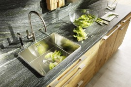 Natural stone countertop and backsplash bring visual contrast to the kitchen