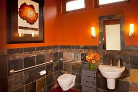 Orange brings dramatic charm to the cool bathroom