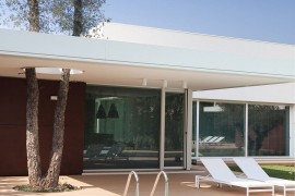 Sliding glass doors connect the interior with the pool area