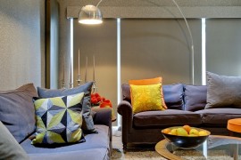 Stylish floor lamp and bright throw pillows enliven the cinema room