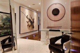 Brilliant art collection of the homeowner stands out visually in the hallway
