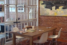 Salvaged windows separate the dining room from the living