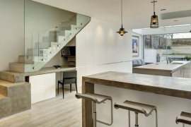 Small workspace under the stairs with ample shelf space next to it