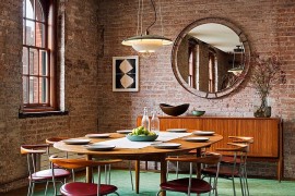 Vintage funiture and a brick wall backdrop shape the unique dining space
