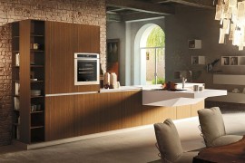 Walnut wooden storage units combine with sleek Corian suspended worktop in the kitchen