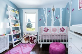 Gorgeous blue nursery with a woodsy theme and a touch of pink