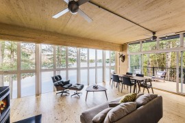 Gorgeous living area enclosed in glass panels overlooking the lake