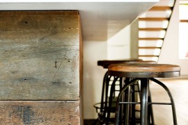 Kitchen island with wood panel covering and stools with an industrial touch