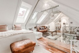 Sitting area and bedroom in the attic seperated by glass walls