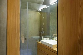 Small bathroom with wooden vanity and shower area