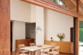 Dining area of the renovated residence with a view of the pond and the landscape outside