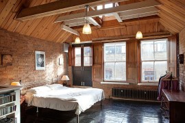 Elegant bedroom with gabled ceiling and brick walls