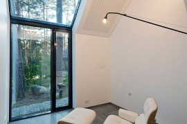 Iconic Eames Lounger sits inside the Black House Blues overlooking the forest