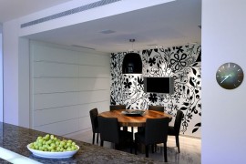 Lighting adds to the appeal of the striking black and white wallpapere in the dining room