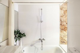 Smart, small bathroom design combines natural stone with all-white modern surfaces
