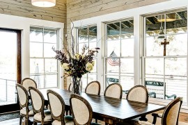 Farmhouse style dining room with high ceiling and glass windows