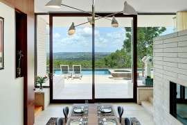 Formal dining area of the Lake View Residence connected visually with the pool deck outside