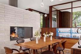 Modern dining room with fireplace and large glass walls
