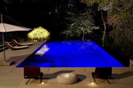 Relaxing backyard with LED pool lighting and an illuminated tree