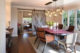 Sliding barn door and brilliant lighting steal the show in this dining room