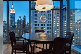 Small dining space in the corner with New York City's sparkling skyline as backdrop