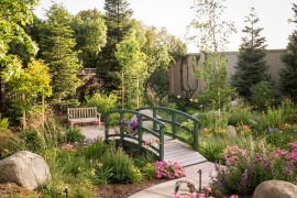 A serene garden with an elegant bridge in French green