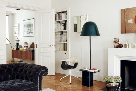 Floor lamp and stylish seating next to the fireplace shape the reading noodk