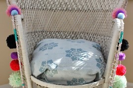 Pom poms adorn a woven peacock chair