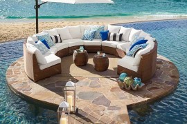 Pottery Barn honey wicker sectional on rounded platform next to ocean