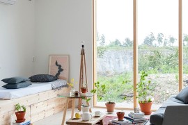 Tiny, informal living space with large glass window [From: Skälsö Arkitekter]