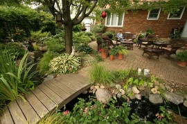 Small urban garden landscape with outdoor living, bridge and a water garden