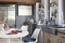 Stone sink and wooden cabinets along with the timeless Tulip chairs in the kitchen
