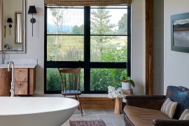 Subtle touches such as the wood pedestal for the bathtub usher in the rustic vibe [Design: Snake River Interiors]