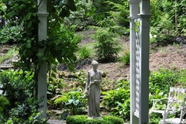 Classic garden design with archway and statue