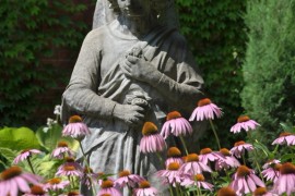 Tall garden statue surrounded by lovely flowers