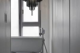 Chandelier above the bathtub adds dark contrast to the interior