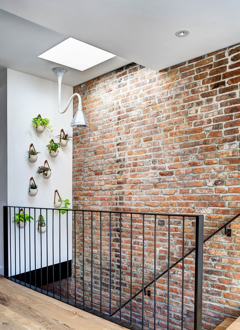 Gorgeous wall planters next to the staircase with skylight above