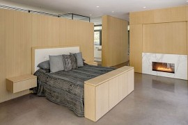 Minimal bedroom with marble fireplace and wooden walls