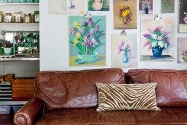 Vintage floral oil paintings shape a lovely gallery wall in this living room [From: Rikki Snyder Photography]