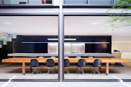 Wooden dining tables stands in contrast to the concrete kitchen island
