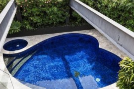 Small heart-shaped pool with a Jacuzzi next to t