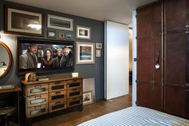 A gallery wall in the bedroom with television and vintage decor