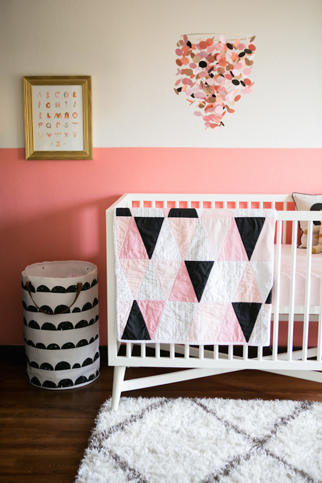 A half painted pink nursery paired with geometric crib bedding