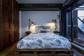 Bedroom with vintage suitcase-styled wardrobe and white brick wall