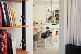 Bright metallic pendant light and colorful chairs for the dining space